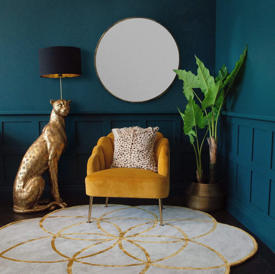 A large round mirror on a wall next to a chair and a floor lamp